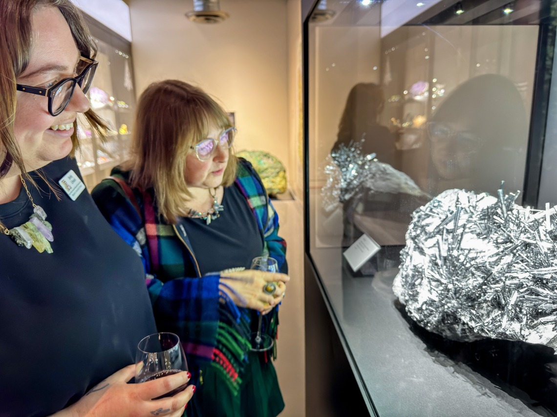Image of museum visitors viewing the donated massive, rare stibnite specimen