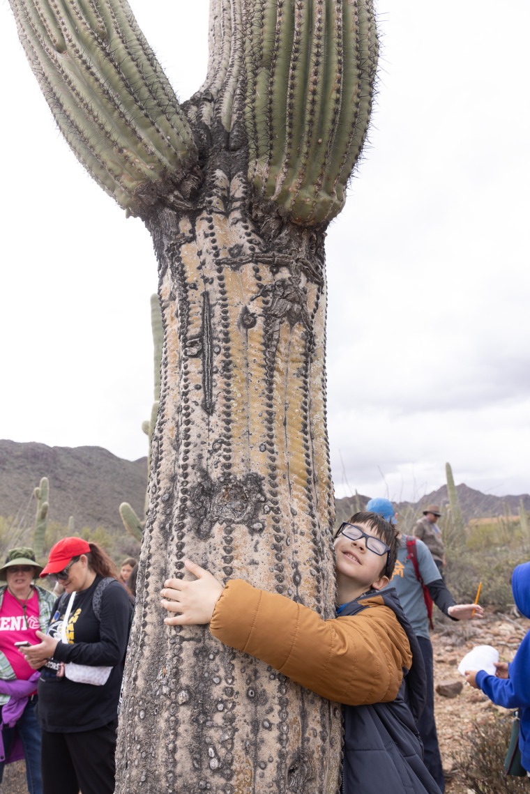 Lineweaver Elementary School student, Zachariah Thurn, hugging a saguaro.