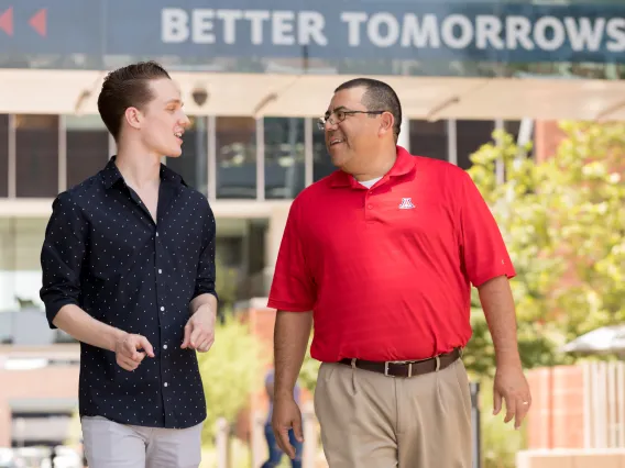 Student walking with older mentor