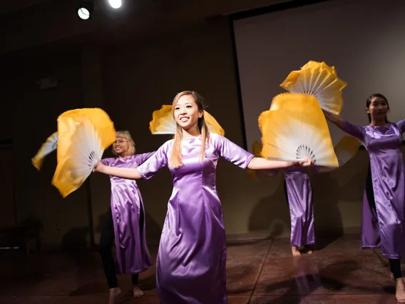 Asian women performing a fan dance