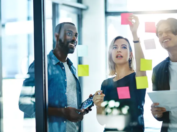 People collaborating and putting notes on a board