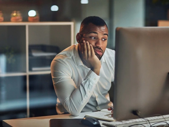 Person looking disappointingly at a computer. 