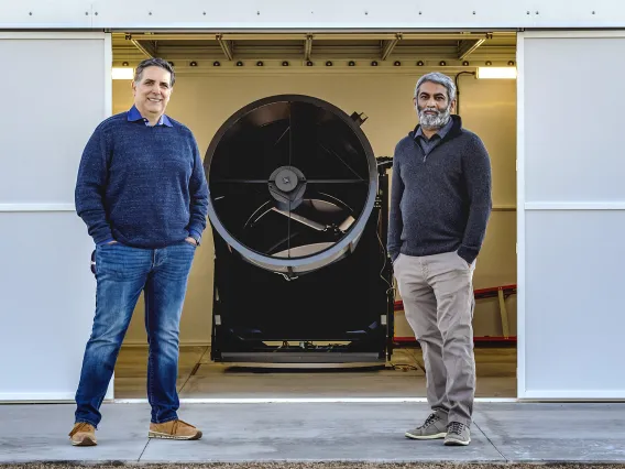 Two men standing in front of machinery 