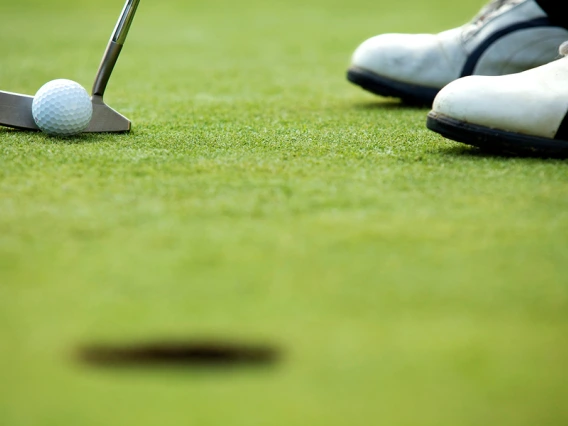 Closeup of a golf ball and putter