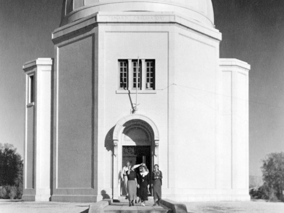 A photograph of five individuals standing outside of the Steward Observatory dome