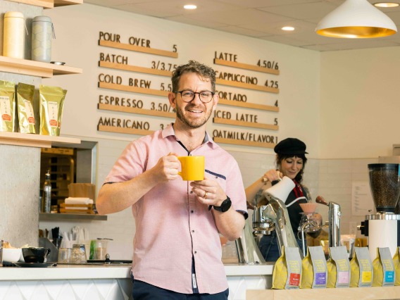 Man holds mug at cafe counter