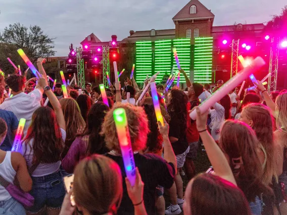 Crowd of young people dance in outdoor setting