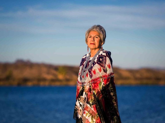 Woman looks across Colorado River landscape in traditional garb