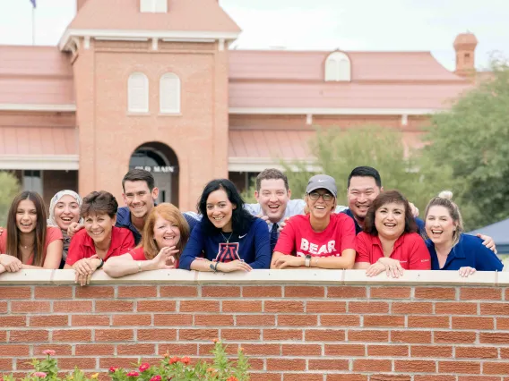 Students stand in group and smile on UArizona campus