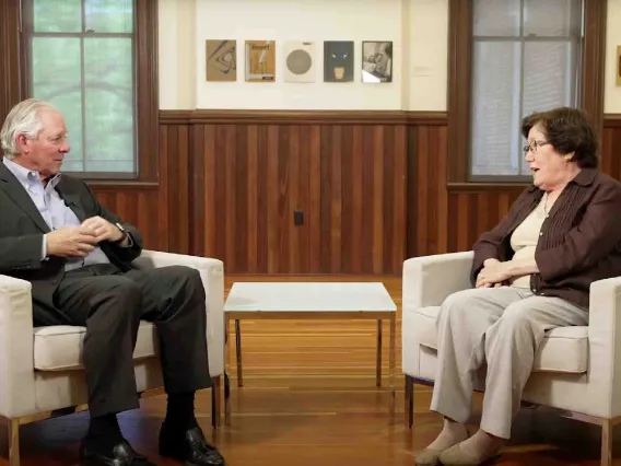 Two professionals engaged in discussion while sitting in white chairs