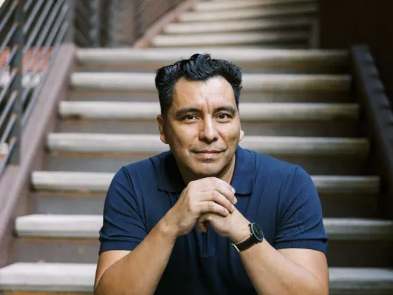 Man sits and poses on steps in portrait