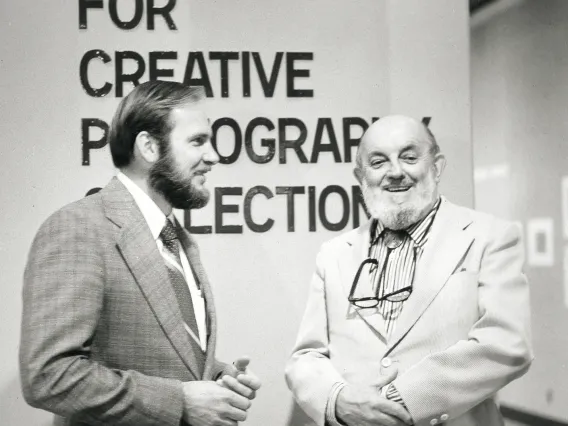Two men smiling in front of The Center for Creative Photography entrance