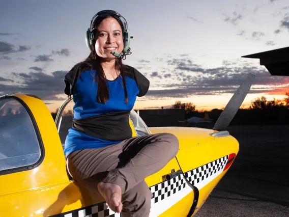 Image of Jessica Cox sitting on top of airplane.