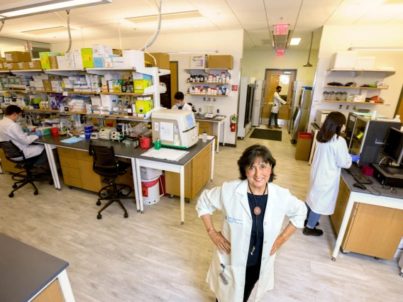 Roberta smiling and looking up while her lab works in the background