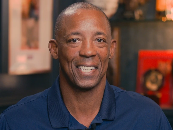 Sean Elliot smiling, wearing a red and blue Arizona polo 