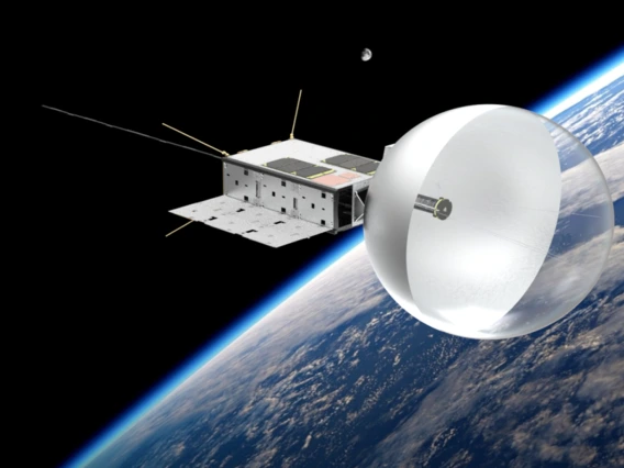 Illustration of the CatSat satellite in low Earth orbit, featuring a deployed balloon-like drag sail, Earth’s curved horizon, and a distant moon.