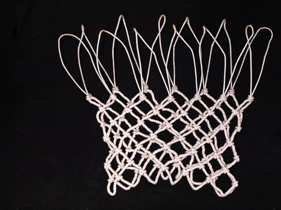 A generated image of a practice basketball net laying flat against a black background.