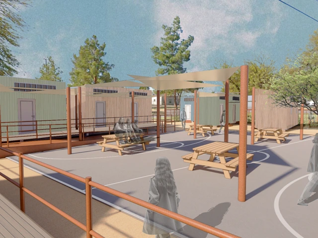 An architectural rendering depicts a shared outdoor courtyard surrounded by compact housing units. Shade sails, picnic tables and accessible walkways create gathering spaces for residents.