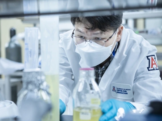 two people smiling and working inside a lab at UACI