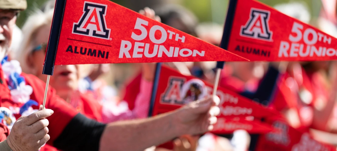 People holding 50th reunion penants