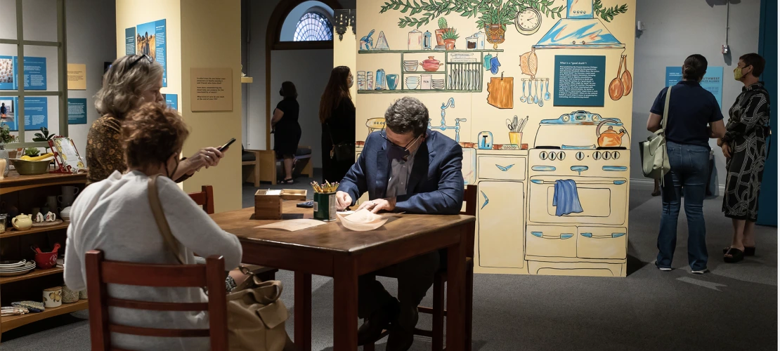 An attendee adds a memory to an interactive component of the exhibit. 