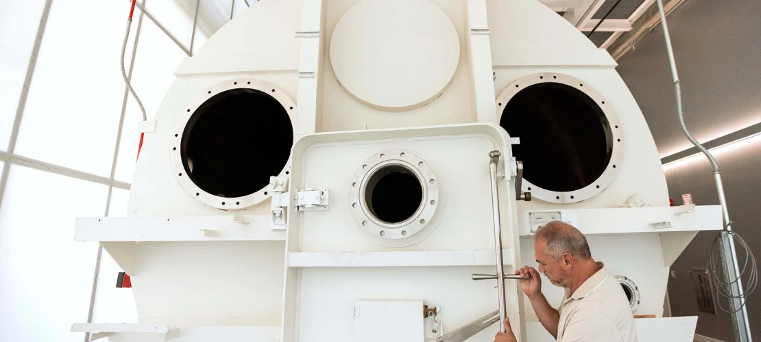 A photograph of a man opening the chamber door 