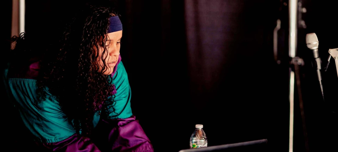 A photograph of a woman working on a computer at a music set.