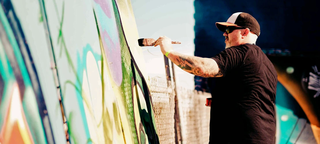 Image of a man painting a mural.