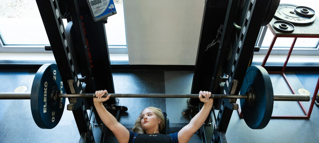 A photograph of a woman holding a weight over her head 