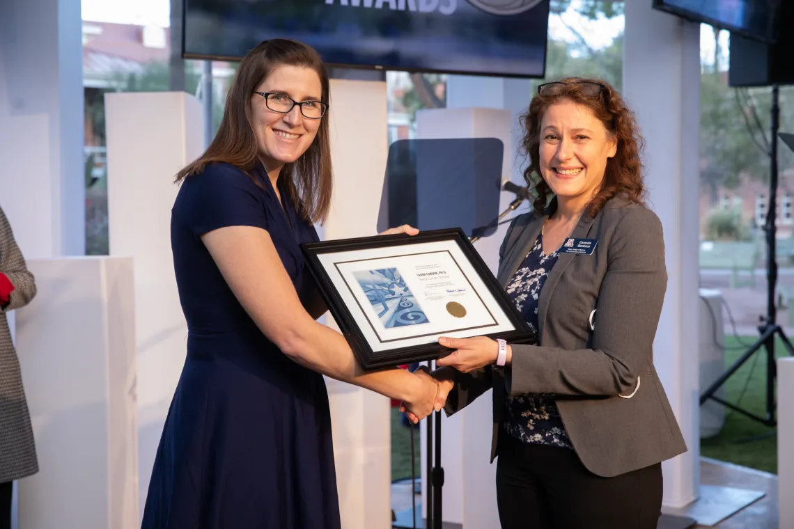 Two women holding a plaque