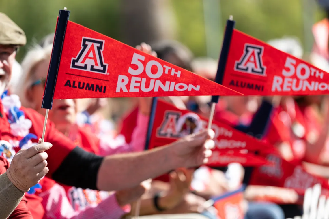 People holding 50th reunion penants