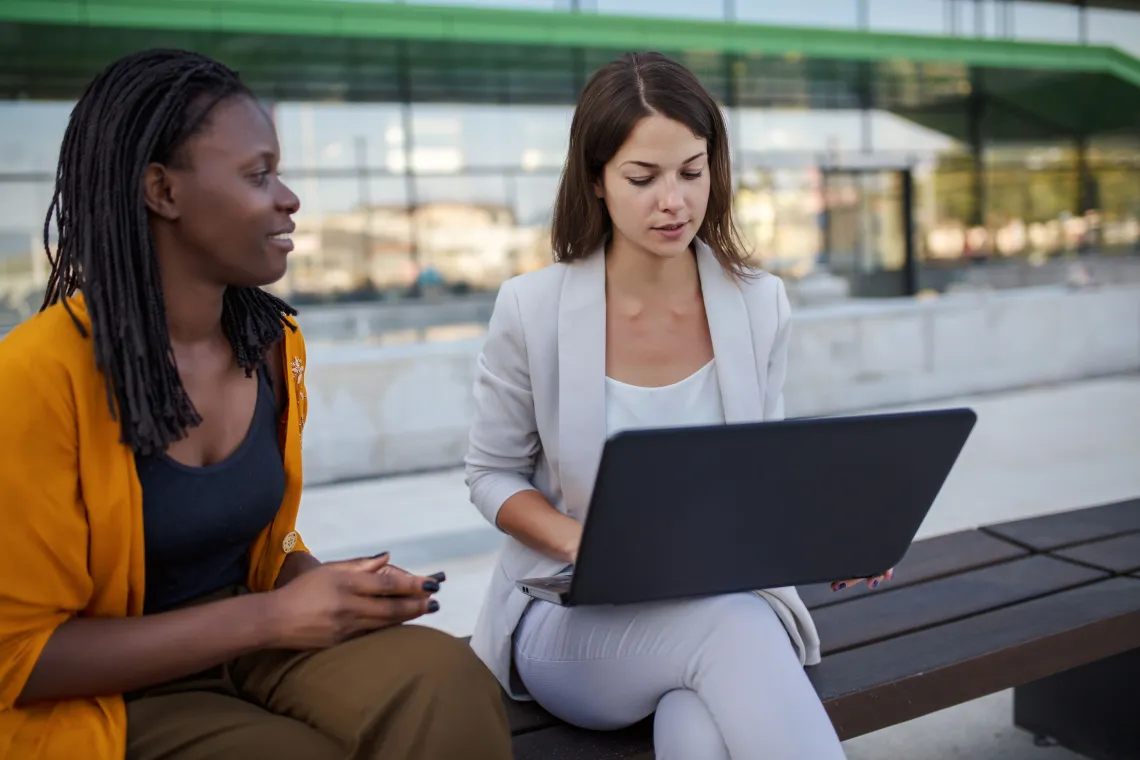 Two people working on a laptop