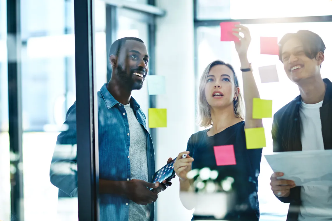 People collaborating and putting notes on a board