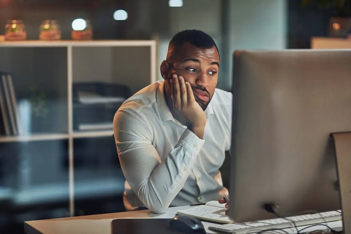 Person looking disappointingly at a computer. 