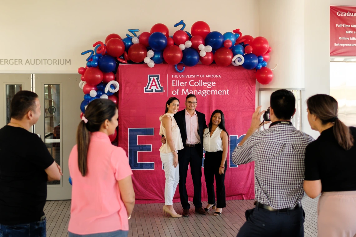 Group of people having their photo taken in front of Eller backdrop