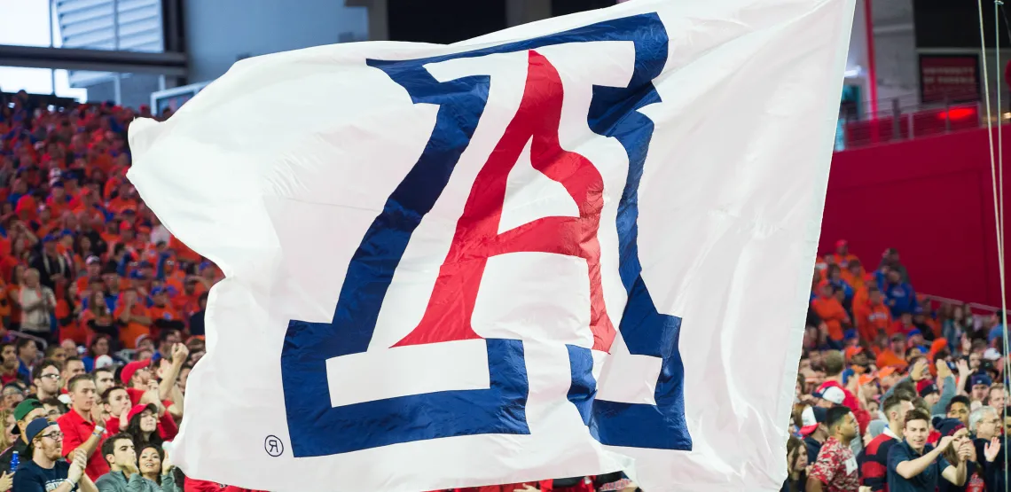 Large "A" flag in front of crowd at a football game