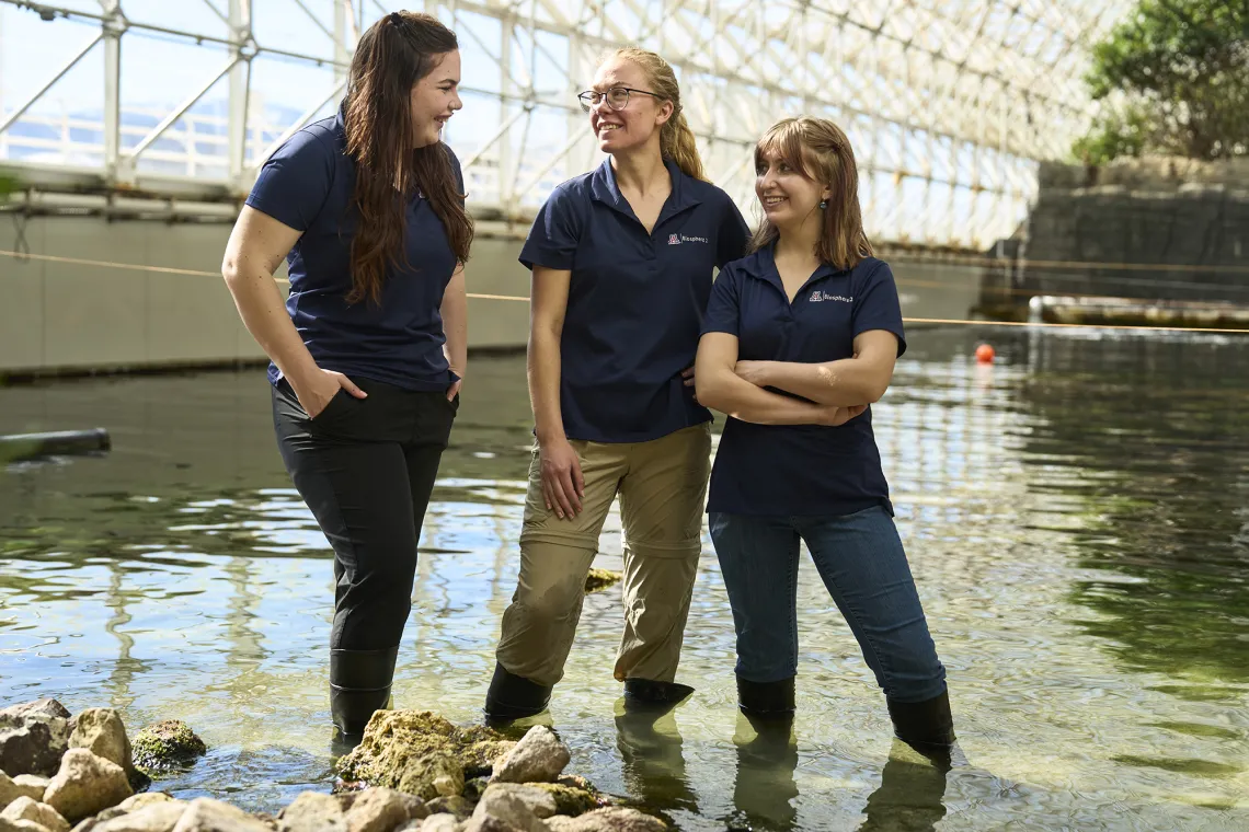 Three women standing in front of water at Biosphere 2