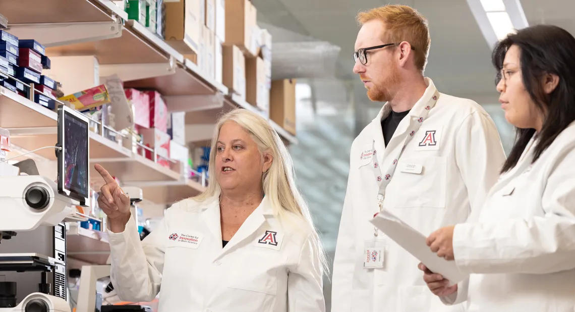 Female researcher talking with two other researchers 