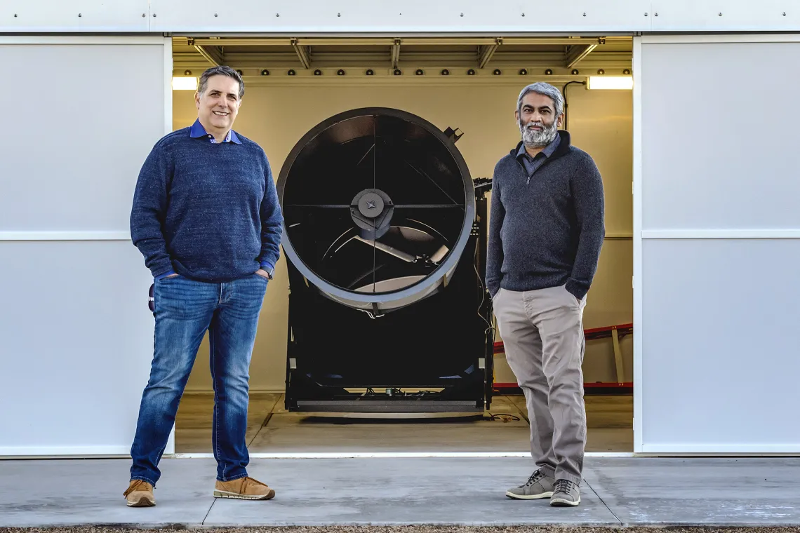 Two men standing in front of machinery 