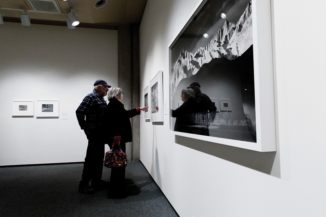 A couple looking at a photograph and pointing at a detail