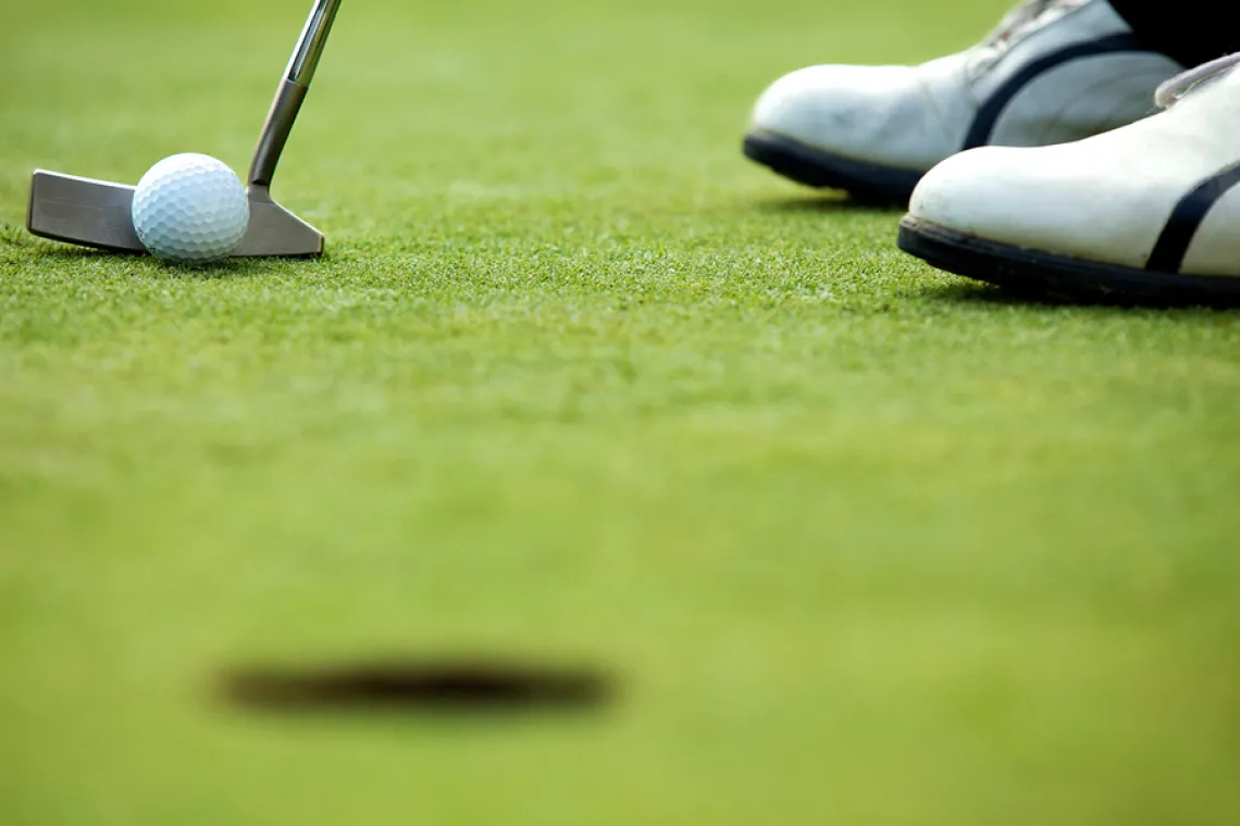 Closeup of a golf ball and putter