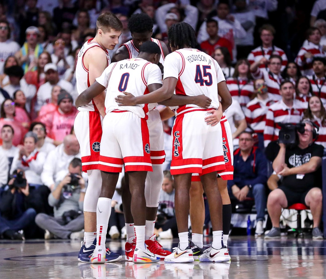 Arizona basketball players huddled together on court