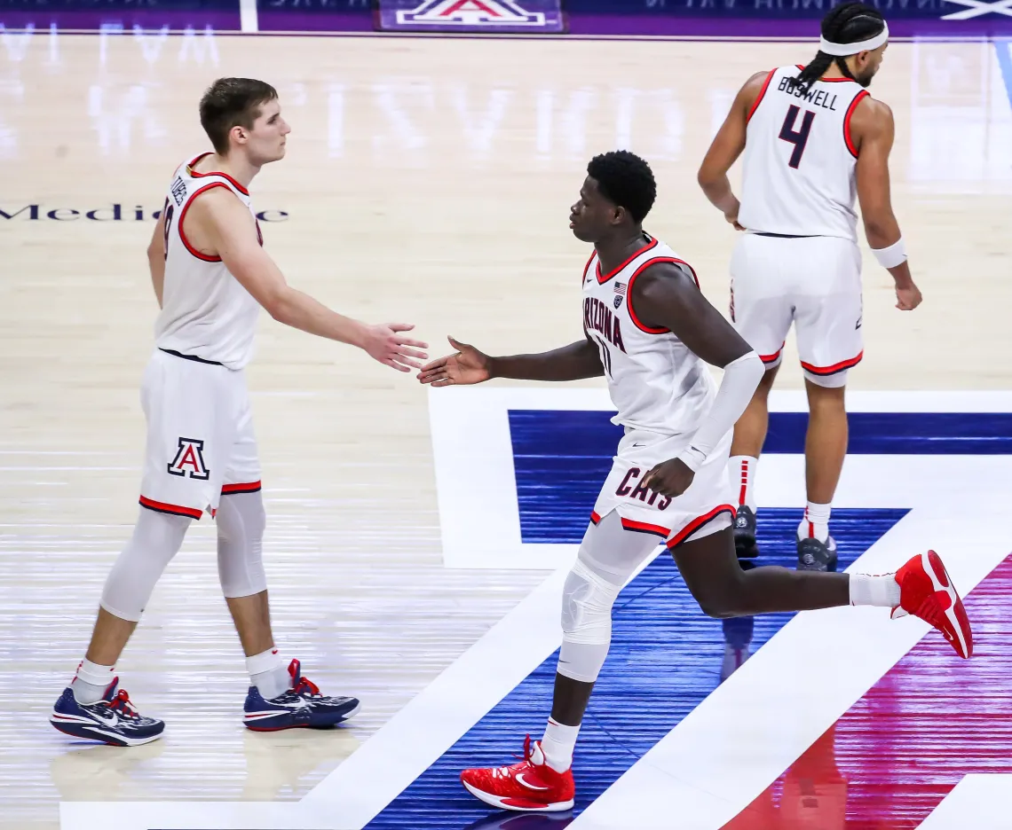 Arizona basketball players high five on court