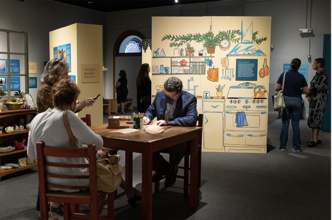 An attendee adds a memory to an interactive component of the exhibit. 