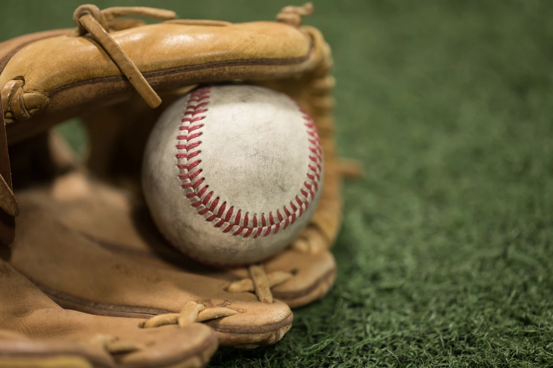 A photograph of a baseball inside of a baseball mitt.