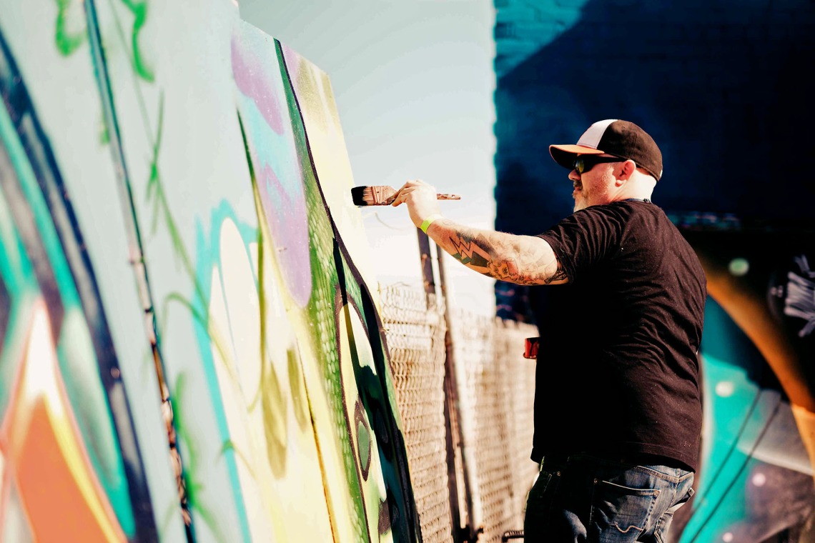 Image of a man painting a mural.