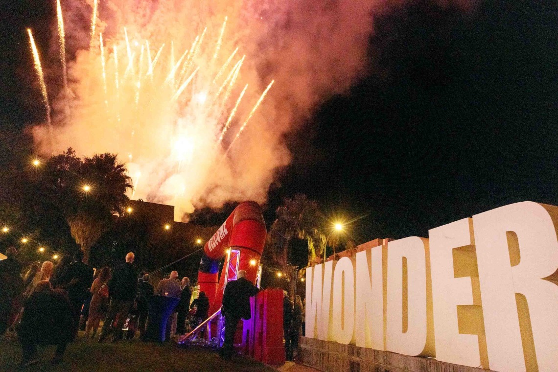 Fireworks display celebrates before large letters on the mall that spell WONDER