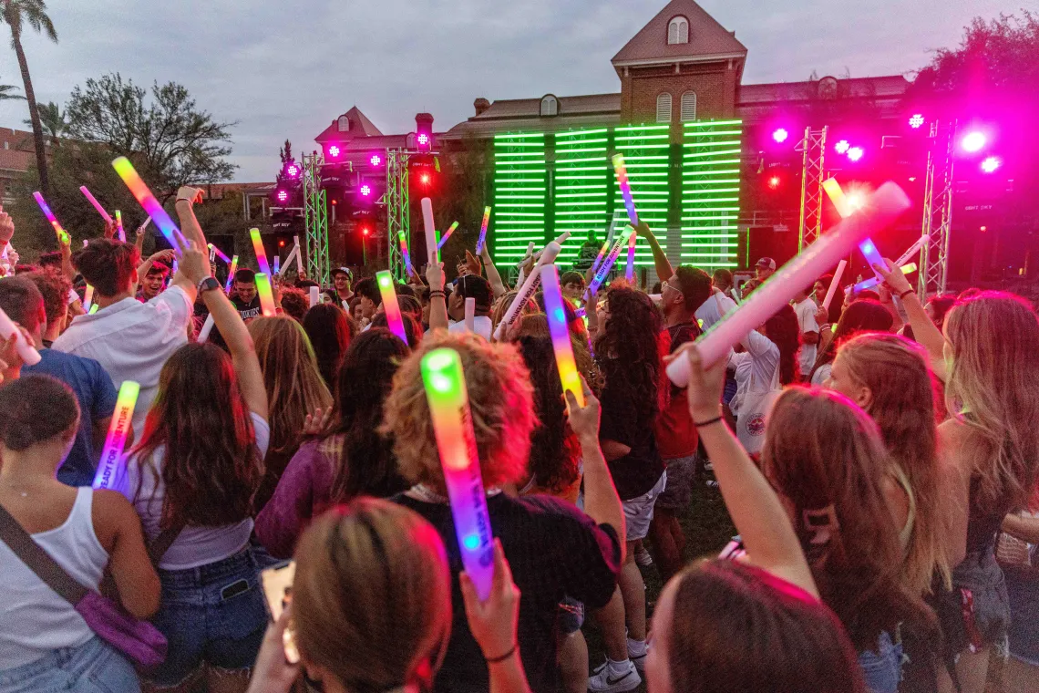 Crowd of young people dance in outdoor setting