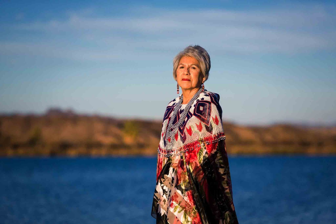 Woman looks across Colorado River landscape in traditional garb