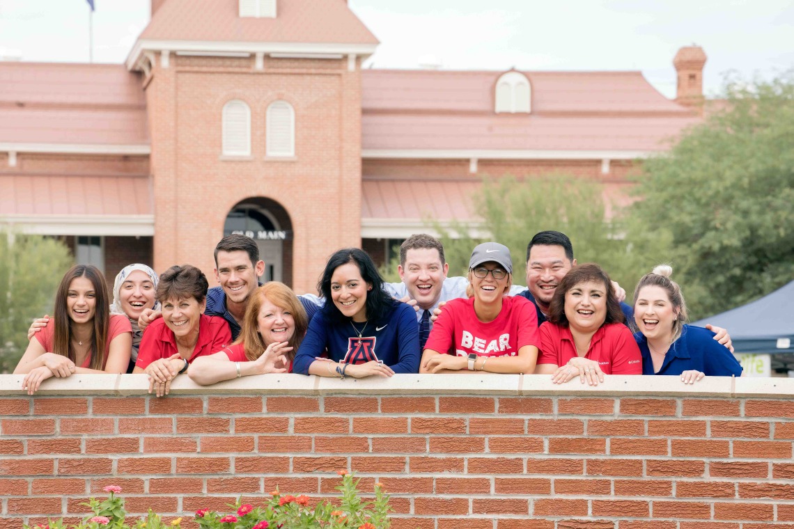 Students stand in group and smile on UArizona campus